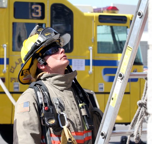 Firefighter looking up ladder